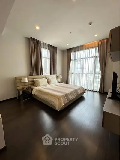 Spacious modern bedroom with large windows and elegant decor