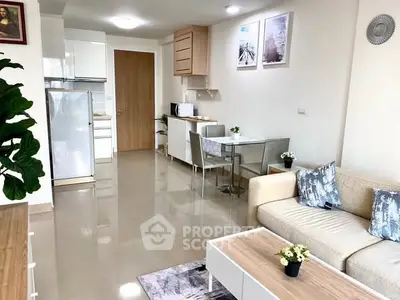 Modern living room with open kitchen, stylish decor, and natural light.