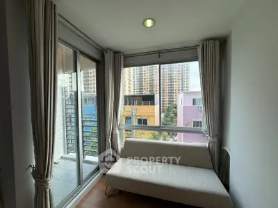 Cozy corner unit with large windows and city view, featuring a modern sofa and elegant curtains.