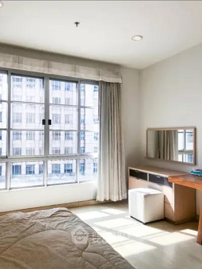 Bright bedroom with large window and modern furniture in urban apartment