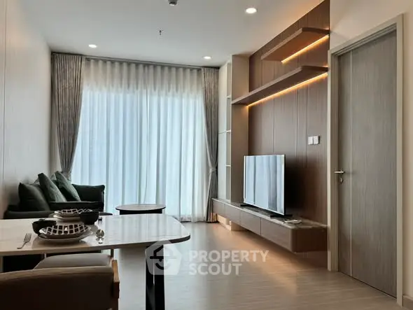 Modern living room with sleek furniture and large window, perfect for urban living.