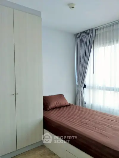 Cozy bedroom with natural light and modern wardrobe in a stylish apartment