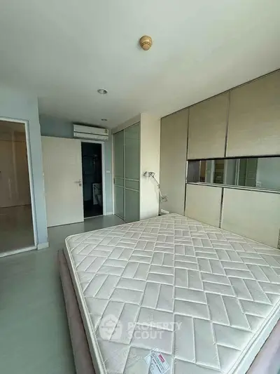 Spacious bedroom with large wardrobe and air conditioning in modern apartment