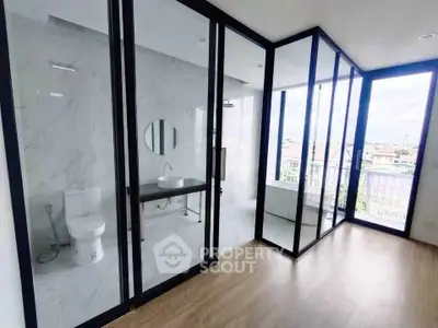 Modern bathroom with glass walls and city view in a high-rise apartment