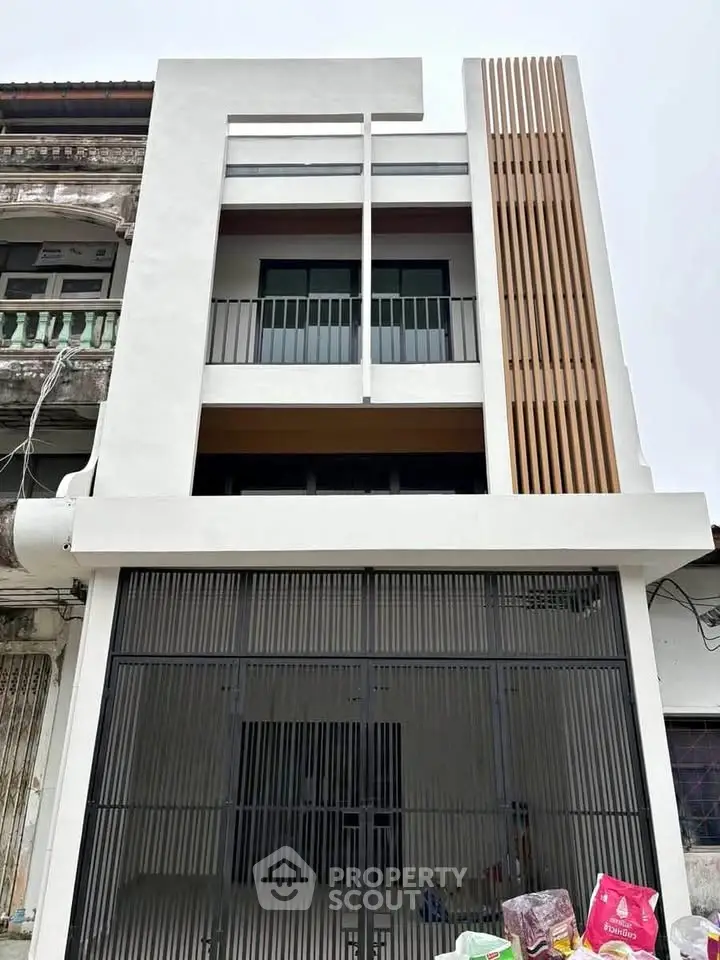 Modern three-story townhouse with sleek facade and balcony