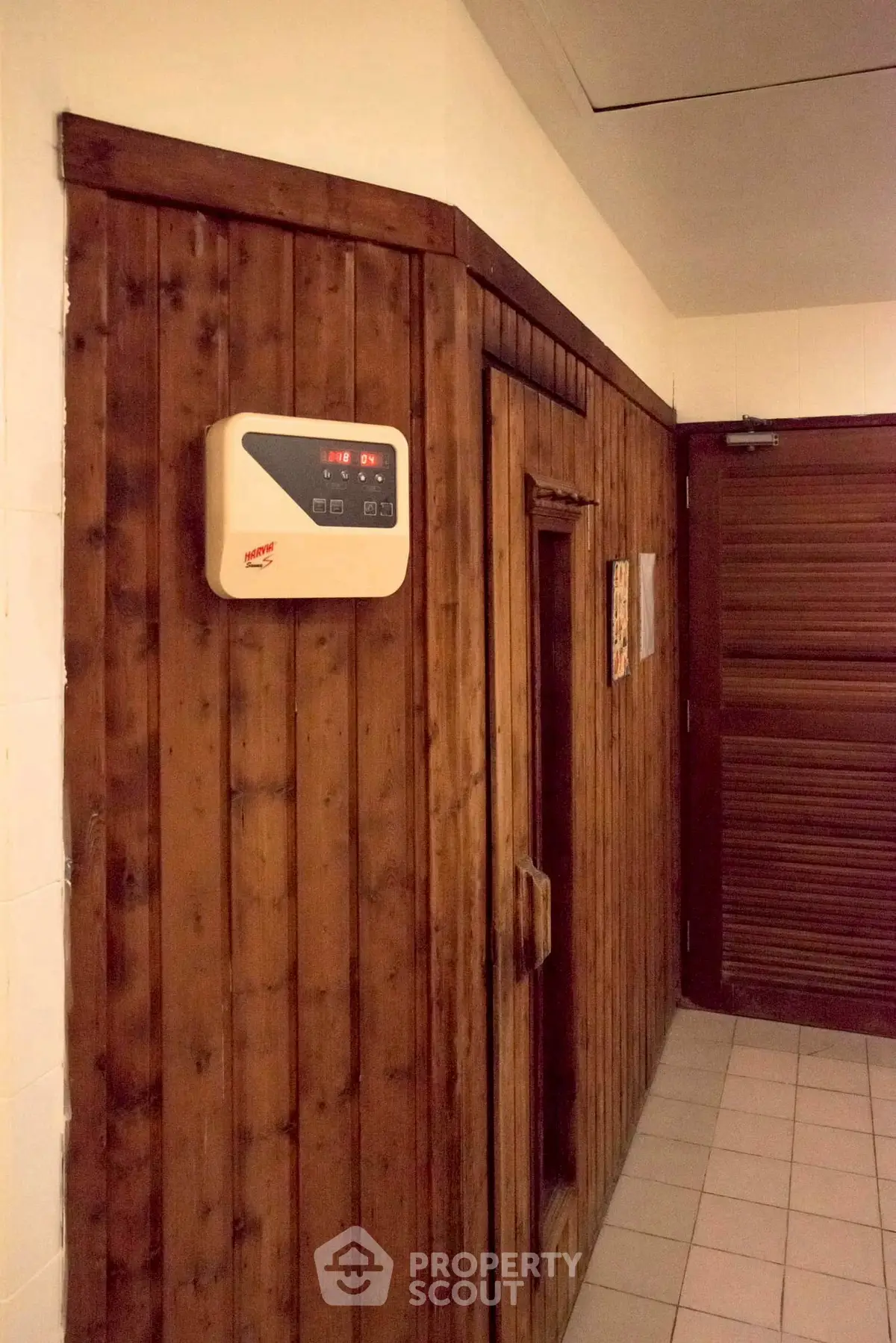 Cozy wooden sauna room with digital control panel in a modern home.