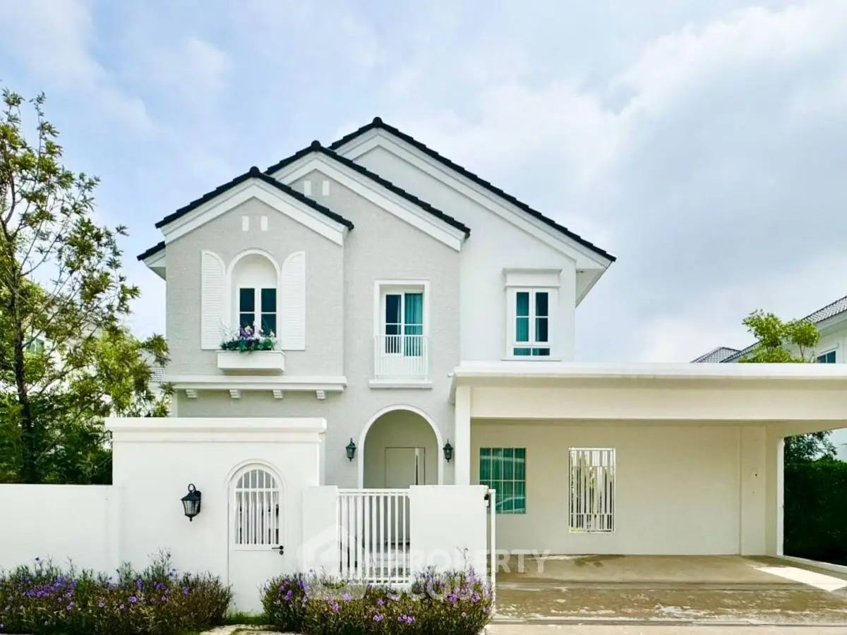 Charming two-story white house with elegant facade and spacious driveway in serene neighborhood.
