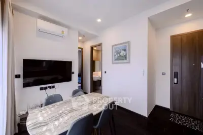 Modern living room with sleek design, featuring a wall-mounted TV and stylish furniture.