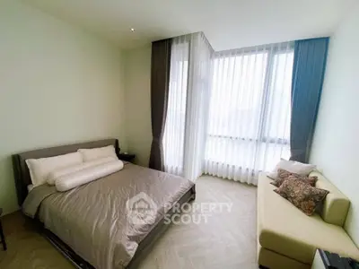 Spacious bedroom with large windows and elegant decor in modern apartment