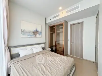 Modern bedroom with stylish decor and spacious closet in a luxury apartment.