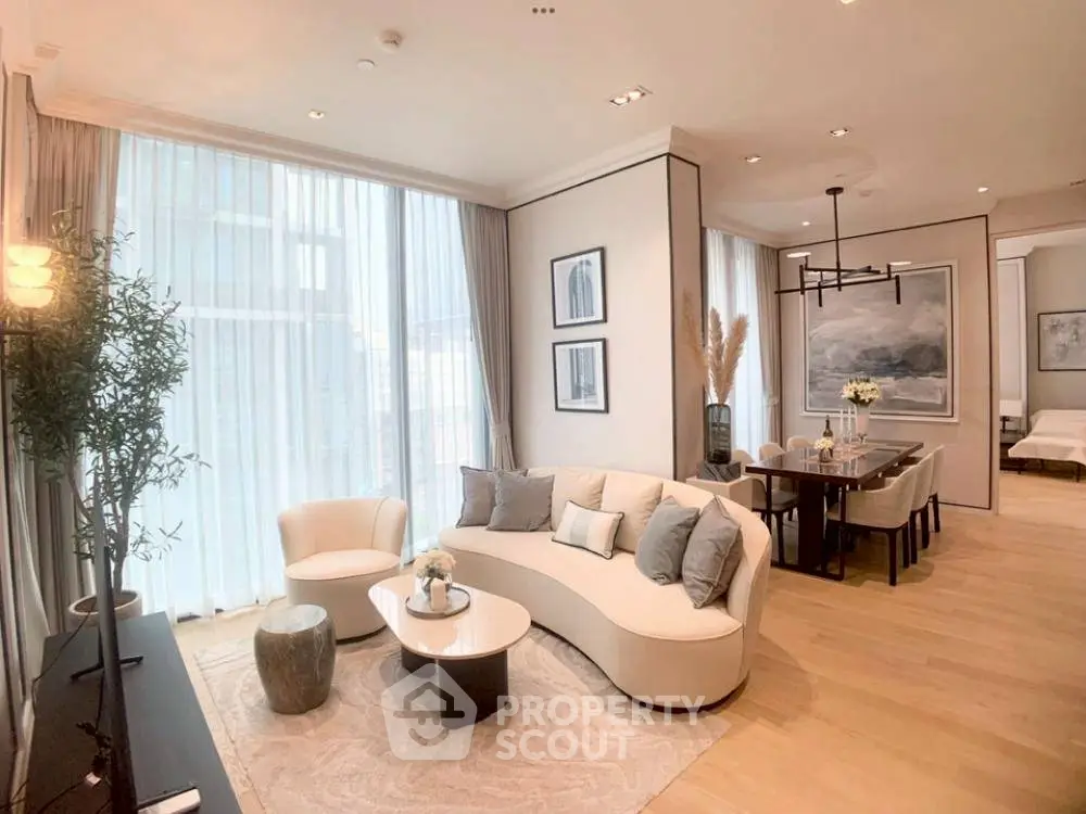 Luxurious open-plan living and dining area with elegant decor and large windows.
