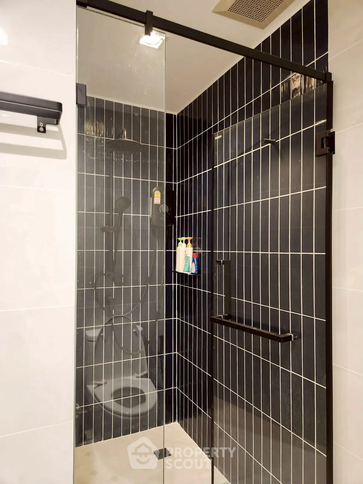 Modern bathroom with sleek black tile shower and glass door
