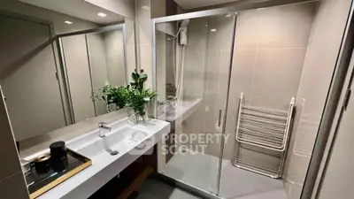 Modern bathroom with sleek shower and elegant vanity in contemporary apartment.