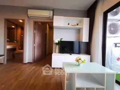 Modern living room with wooden flooring, air conditioning, and stylish TV unit.