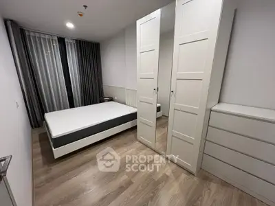 Modern bedroom with sleek design, featuring a mirrored wardrobe and minimalist decor.