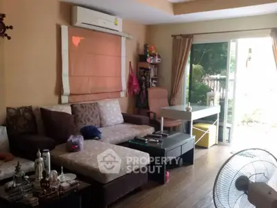 Cozy living room with modern decor and garden view, featuring comfortable seating and natural light.