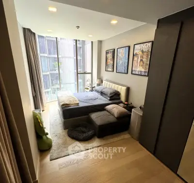 Modern bedroom with floor-to-ceiling windows and stylish decor in urban apartment.