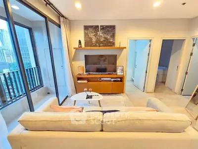 Modern living room with balcony view and stylish decor in urban apartment.