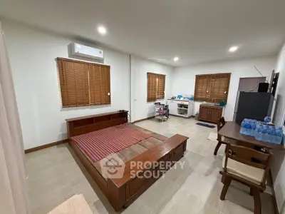 Spacious bedroom with wooden furniture and modern amenities in a cozy apartment.