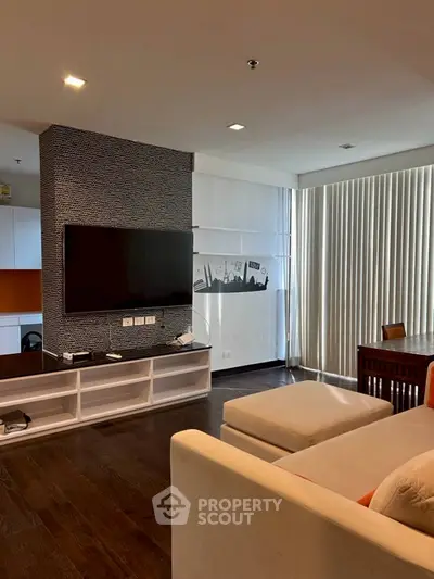 Modern living room with TV, stylish decor, and cozy seating area.