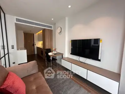 Modern living room with sleek TV setup and cozy seating in stylish apartment.