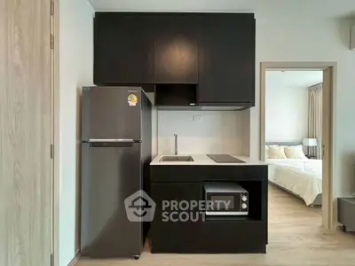 Modern kitchen with sleek black cabinets and appliances in stylish apartment