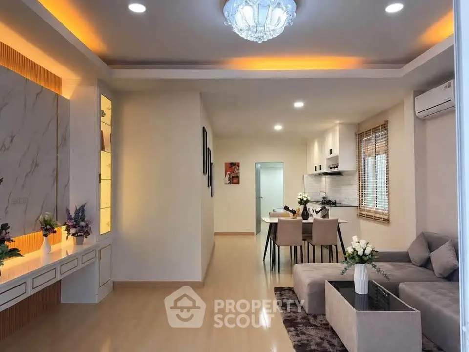 Modern living room with open layout, elegant lighting, and stylish decor in a cozy apartment.