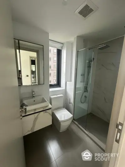 Modern bathroom with sleek fixtures and large window in urban apartment