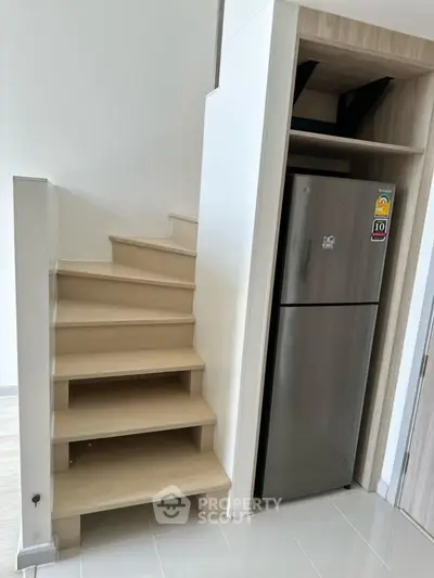 Modern staircase with built-in fridge in compact living space