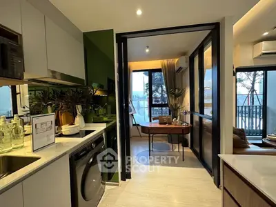 Modern kitchen with open layout and dining area, featuring sleek appliances and stylish decor.