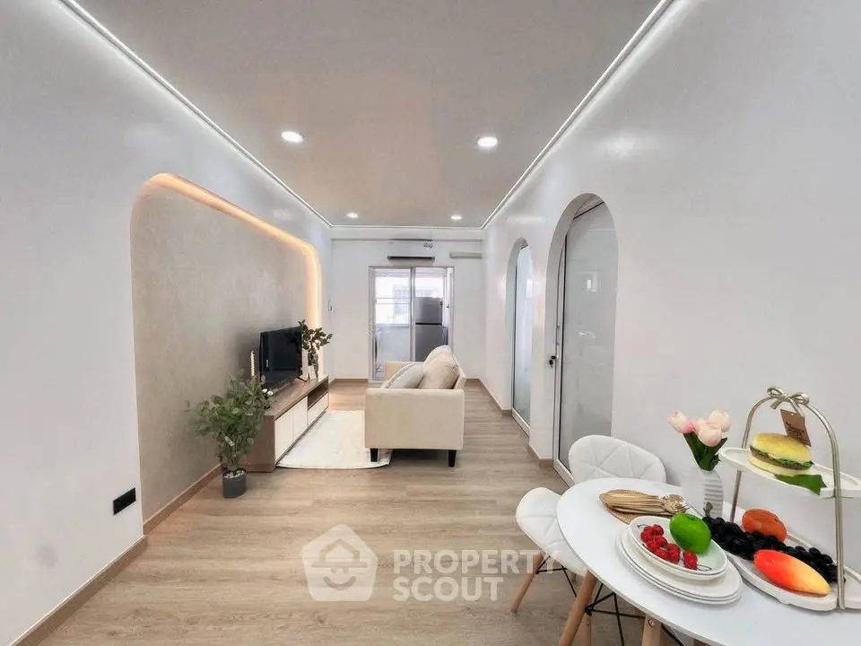 Modern living room with stylish decor and open layout, featuring cozy seating and elegant dining area.