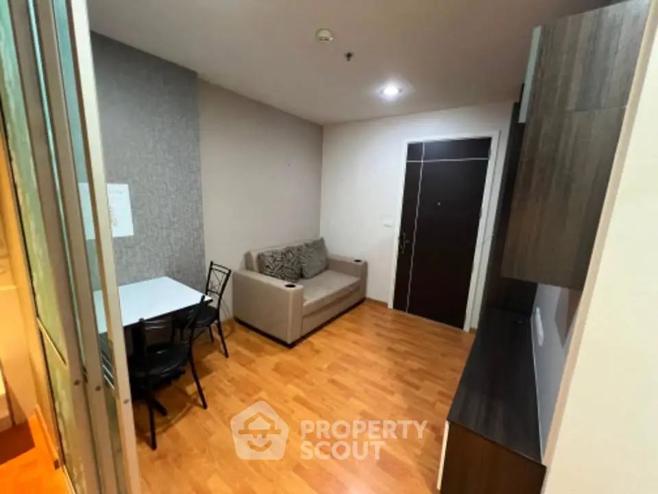 Cozy living room with modern decor and wooden flooring in a compact apartment.