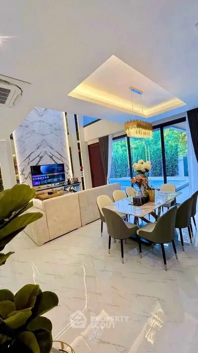 Luxurious open-plan living and dining area with elegant decor and garden view.