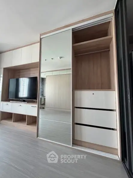 Modern living room with sleek built-in wardrobe and entertainment unit, showcasing contemporary design and functionality.