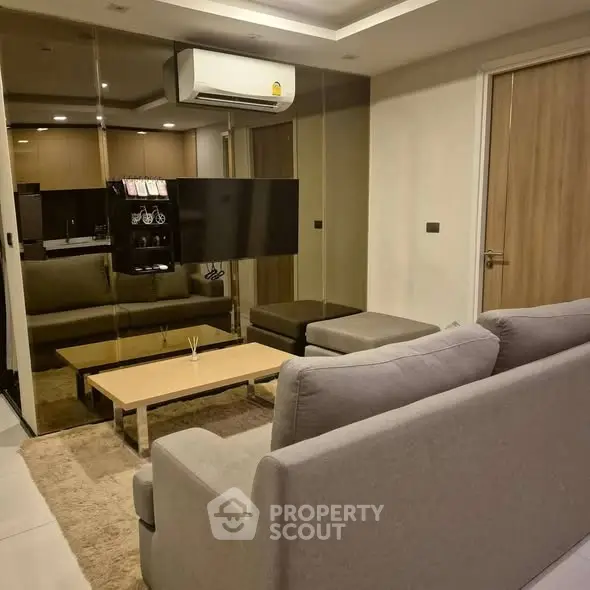 Modern living room with sleek furniture and mirrored wall in stylish apartment