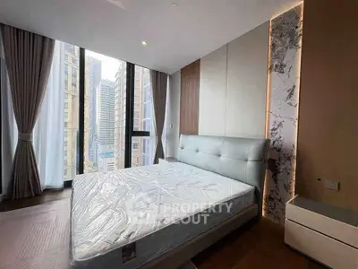 Luxurious bedroom with stunning city view and modern design in high-rise apartment.
