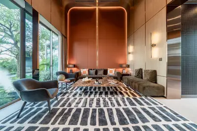 Luxurious modern living room with elegant decor and large windows offering garden views.