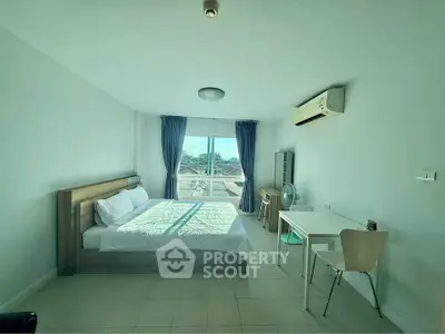 Bright and airy bedroom with modern furnishings and large window view.