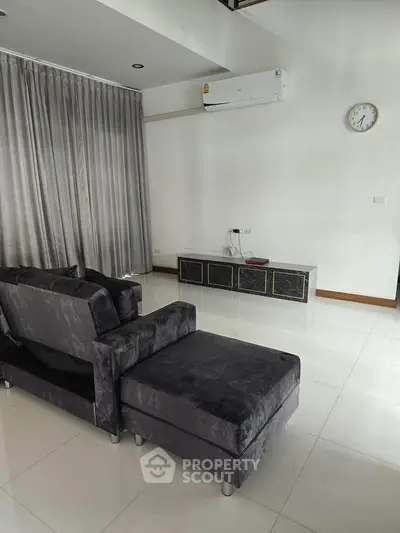 Spacious modern living room with sleek furniture and air conditioning
