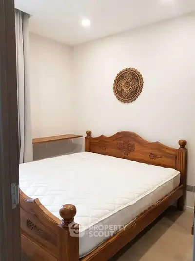 Cozy bedroom with wooden bed frame and decorative wall art, perfect for a serene retreat.