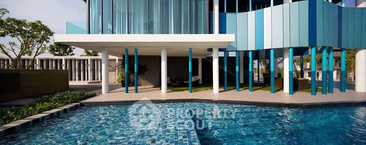 Modern luxury building with stunning pool and unique architectural design.