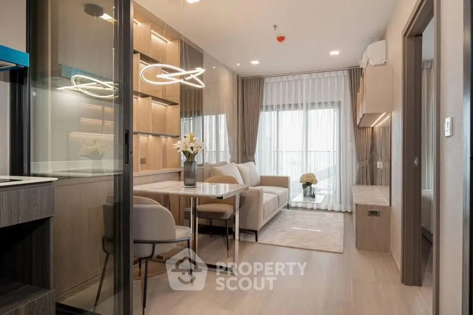 Modern living room with elegant decor and natural light, featuring a cozy seating area and stylish lighting.