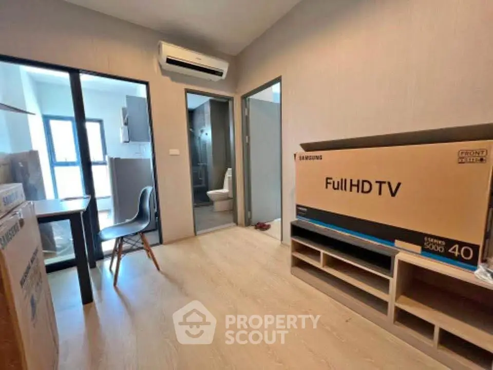 Modern apartment interior with boxed TV and air conditioning, showcasing a cozy living space.