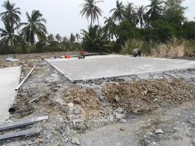 Construction site with concrete foundation and tropical background
