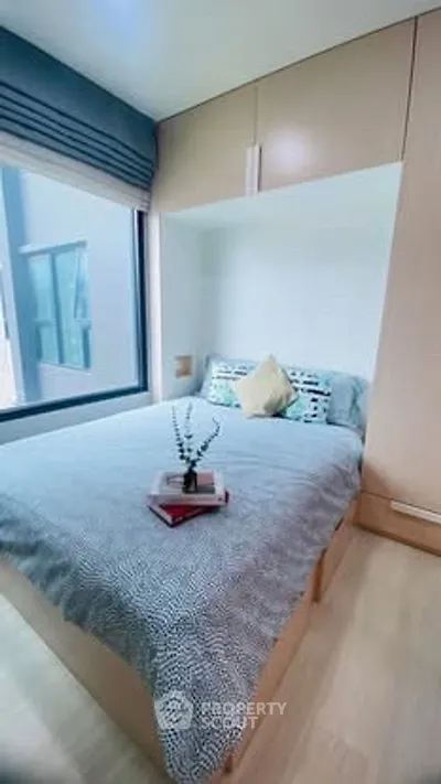 Cozy bedroom with modern decor and large window for natural light