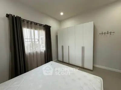 Spacious bedroom with modern wardrobe and natural light