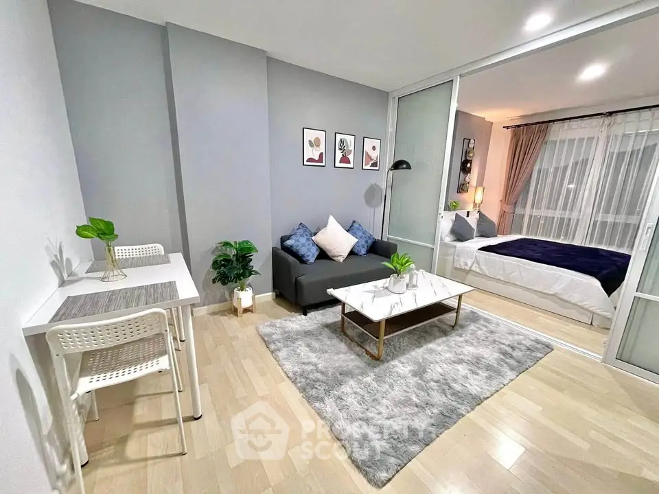Modern studio apartment with stylish living area and cozy bedroom, featuring sleek decor and natural light.