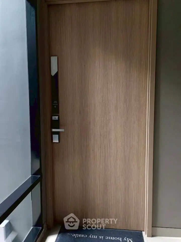 Modern apartment entrance with sleek wooden door and digital lock system.