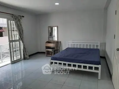 Spacious bedroom with balcony access and minimalist furniture