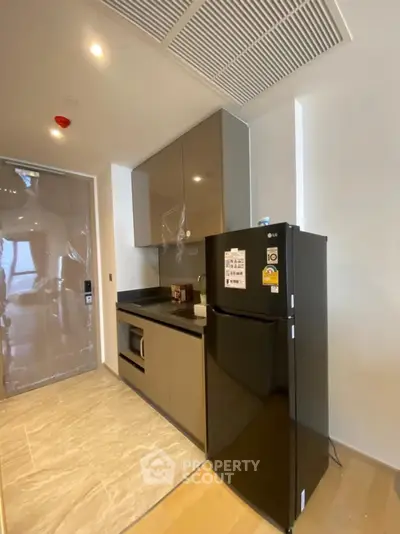 Modern kitchen with sleek cabinets and black fridge in a stylish apartment
